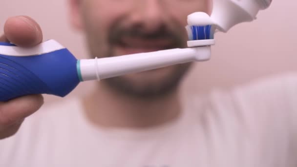 Hombre barbudo comienza a cepillarse los dientes en el espejo — Vídeos de Stock