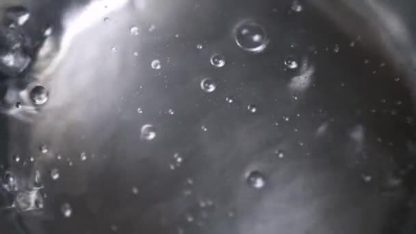 Voda vaří v kovové misce, střední bubliny — Stock video