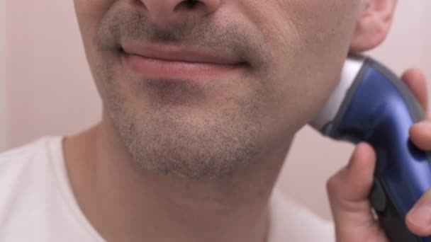 Afeitarse un hombre sonriente, afeitadora maquinilla de afeitar eléctrica — Vídeos de Stock