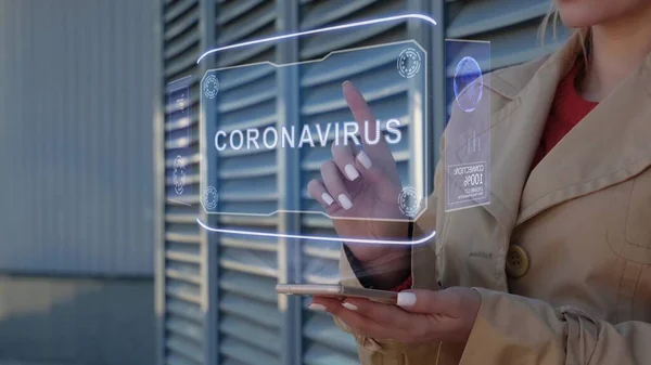Pengusaha wanita berinteraksi HUD hologram dengan teks Coronavirus Stok Gambar Bebas Royalti