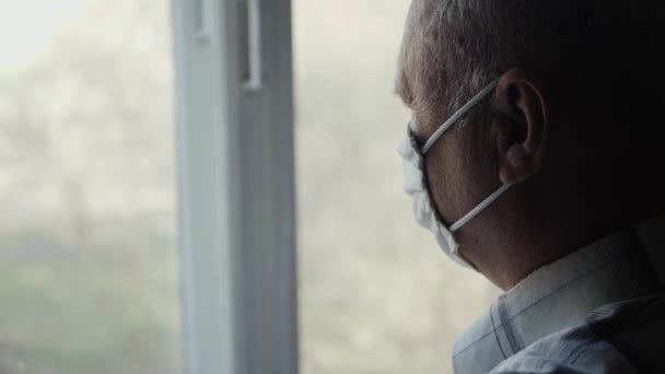 Un homme âgé regarde par la fenêtre — Video