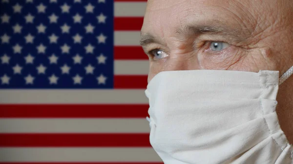 Hombre mayor en máscara protectora hecha a mano EE.UU. bandera de fondo Imagen De Stock