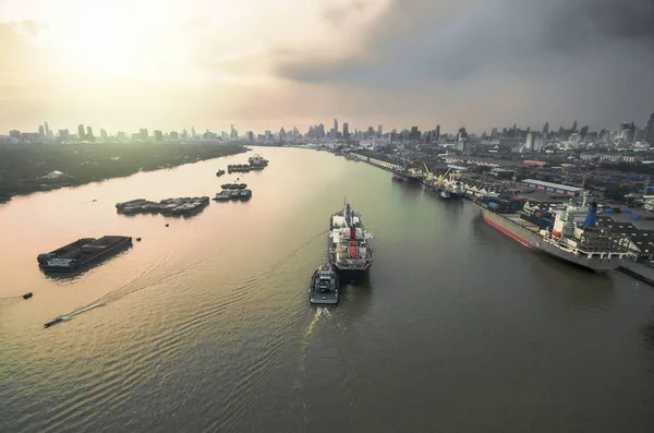 two tug boat towing cargo container in warehouse harbor at city