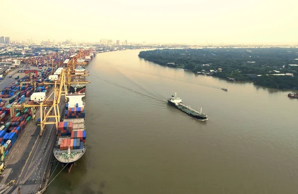 two tug boat towing cargo container in warehouse harbor at city