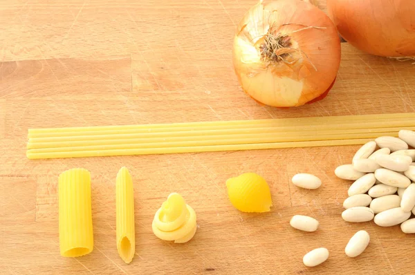 Vários tipos de macarrão italiano, feijão e cebola de cima — Fotografia de Stock