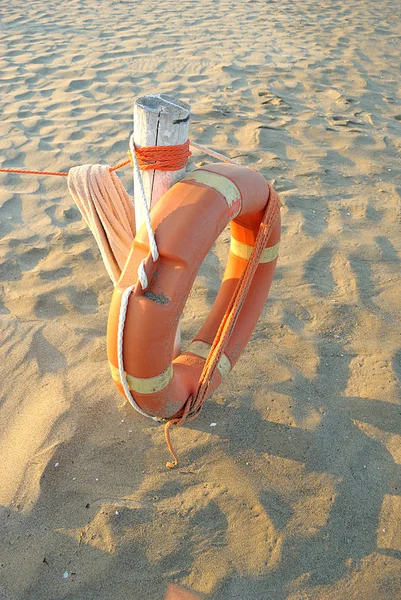 Summer sea, lifebuoy on white bollard on the sand, vertical — Stock Photo, Image