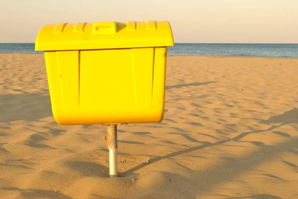 Summer sea, yellow basket for trash on the beach — Stock Photo, Image