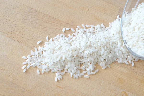 Ansicht von oben von Reis verschüttet aus einer Schüssel auf einem Holztisch — Stockfoto