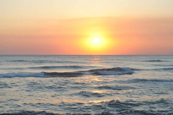 Dalgalar deniz üzerinde turuncu günbatımı — Stok fotoğraf