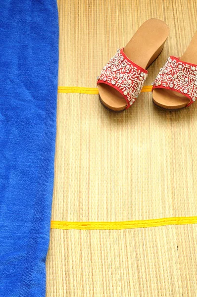 赤いサンダルと青いタオル、コンセプトの竹マットのトップ ビュー — ストック写真