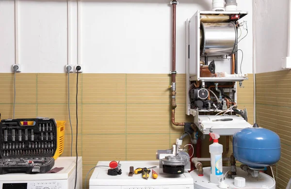 plumber fixing central heating system, Worker servicing a gas boiler