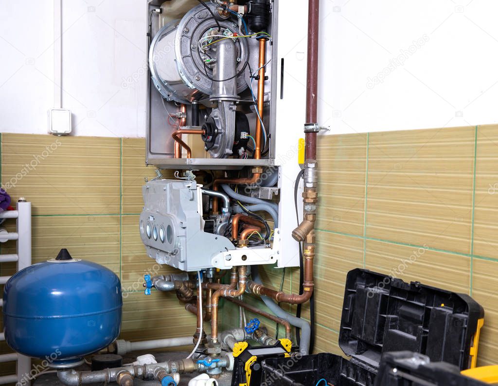 plumber fixing central heating system, Worker servicing a gas boiler