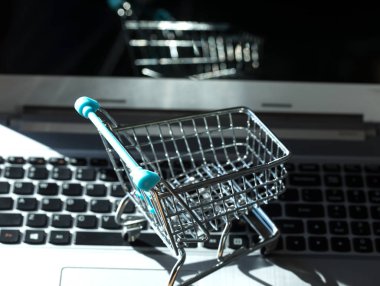 İnternetten alışveriş yapmak - alışveriş arabası ya da dizüstü bilgisayarda tramvay. İnternet 'te alışveriş hizmeti.