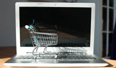 İnternetten alışveriş yapmak - alışveriş arabası ya da dizüstü bilgisayarda tramvay. İnternet 'te alışveriş hizmeti.