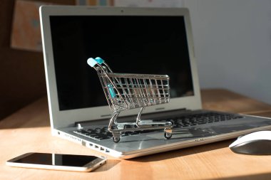 İnternetten alışveriş yapmak - alışveriş arabası ya da dizüstü bilgisayarda tramvay. İnternet 'te alışveriş hizmeti.