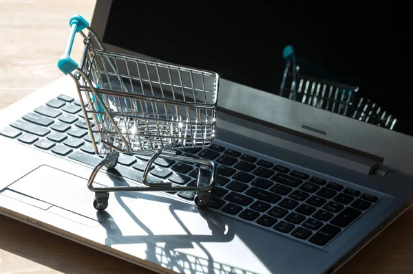 Shopping online concept - shopping cart or trolley on a laptop keyboard. Shopping service on The online web.