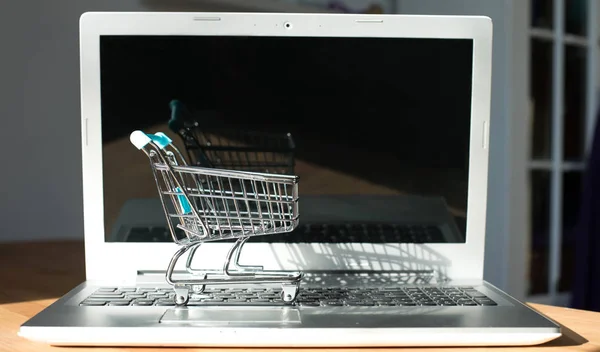 Conceito online de compras - carrinho de compras ou carrinho de mão em um teclado de laptop. Serviço de compras na web online . — Fotografia de Stock