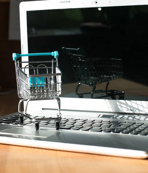 Conceito online de compras - carrinho de compras ou carrinho de mão em um teclado de laptop. Serviço de compras na web online . — Fotografia de Stock