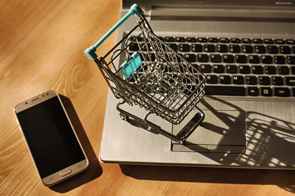 Conceito online de compras - carrinho de compras ou carrinho de mão em um teclado de laptop. Serviço de compras na web online . — Fotografia de Stock