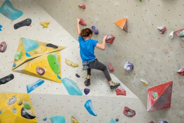 Boy on climbing wall, Bouldersport , boy climbing a rock wall indoor