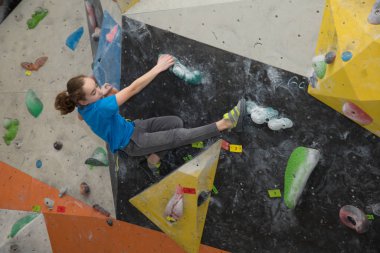 Boy on climbing wall, Bouldersport , boy climbing a rock wall indoor