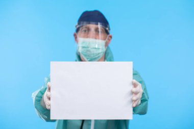 Mavi arkaplanda Coronavirus metnini durduran tıbbi maskeli doktor