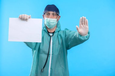 Mavi arkaplanda Coronavirus metnini durduran tıbbi maskeli doktor