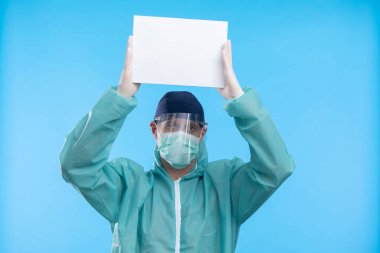 Mavi arkaplanda Coronavirus metnini durduran tıbbi maskeli doktor