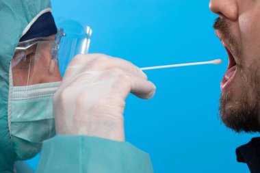 Doktor tükürük testi örneği alıyor.