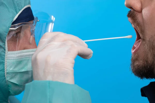 Doktor tükürük testi örneği alıyor.