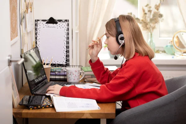 Covid-19 Coronavirus ve evden öğrenme, ev okulu çocuk konsepti. Kız evde ders çalışıyor. Karantina ve Sosyal Mesafe