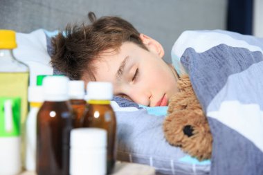 Hasta çocuk yatakta yatıyor, Flue ve ateş, hasta çocuk yatakta yatıyor, ateşi var, dinleniyor.