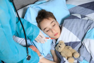 Anne ve çocuğu karantinaya alındı. Sağlık konsepti. Corona Virüsü. Hastalıklı çocuk karantinada Mather ve Coronavirus konseptiyle yatakta yatıyor.