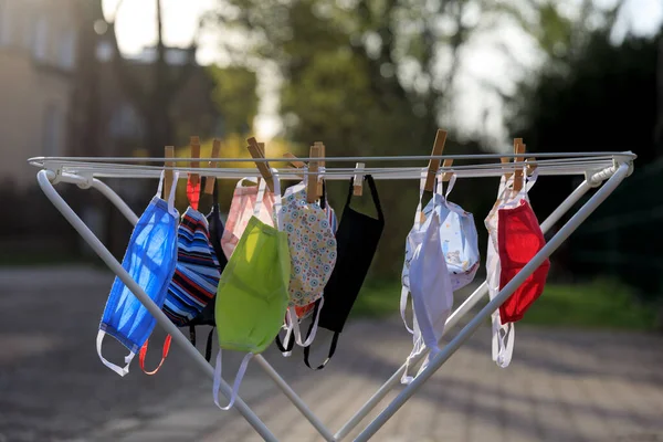 Drying mask hanging under the sun after use for disinfecting. Hygienic mask hanging on the rack outdoor after being washed for cleanness and hygiene during Covid-19 virus outbreak