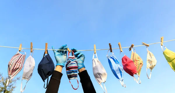 Dezenfekte için kullanıldıktan sonra güneşin altında sallanan kuru maske. Hijyenik maske, Covid-19 virüs salgını sırasında temizlik ve hijyen için yıkandıktan sonra rafta asılı duruyor.