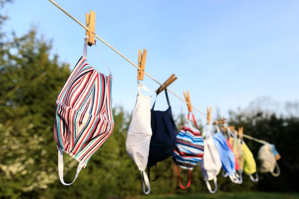 Dezenfekte için kullanıldıktan sonra güneşin altında sallanan kuru maske. Hijyenik maske, Covid-19 virüs salgını sırasında temizlik ve hijyen için yıkandıktan sonra rafta asılı duruyor.