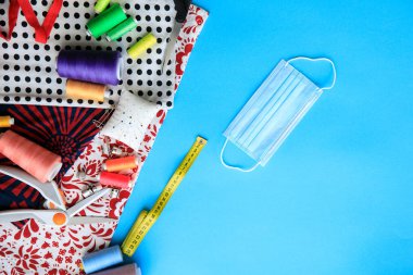 Ev yapımı tekstil yüz, burun ve ağız maskesi virüse karşı. Bir covid-19 salgını sırasında evde koruyucu yüz maskeleri dikmek. Moda maskesi kumaş pamuktan el yapımı.