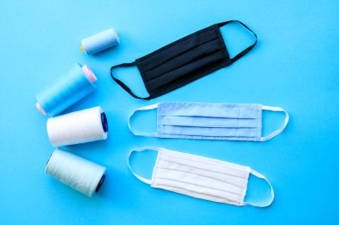 Mavi arka planda tıbbi yüz maskeleri. Koronavirüs, grip ve diğer hava enfeksiyonlarına karşı koruma. Koronavirüse karşı antiviral solunum maskesi takın.
