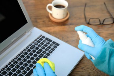 Evde temizlik yapmak, ofiste antibakteriyel dezenfektan spreyi sıkmak koronavirüse karşı, mavi eldivenli eller. Hastanenin arındırılması, ofis alanının önlenmesi. COVID-19 patlamasından önce dezenfeksiyon yüzeyi