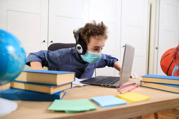 Distance learning online education. A schoolboy boy studies at home and does school homework. A home distance learning , Coronavirus pandemic in the world. Closing schools