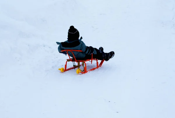 Ein Kind Auf Einem Schlitten Fährt Einen Hügel Hinunter — Stockfoto