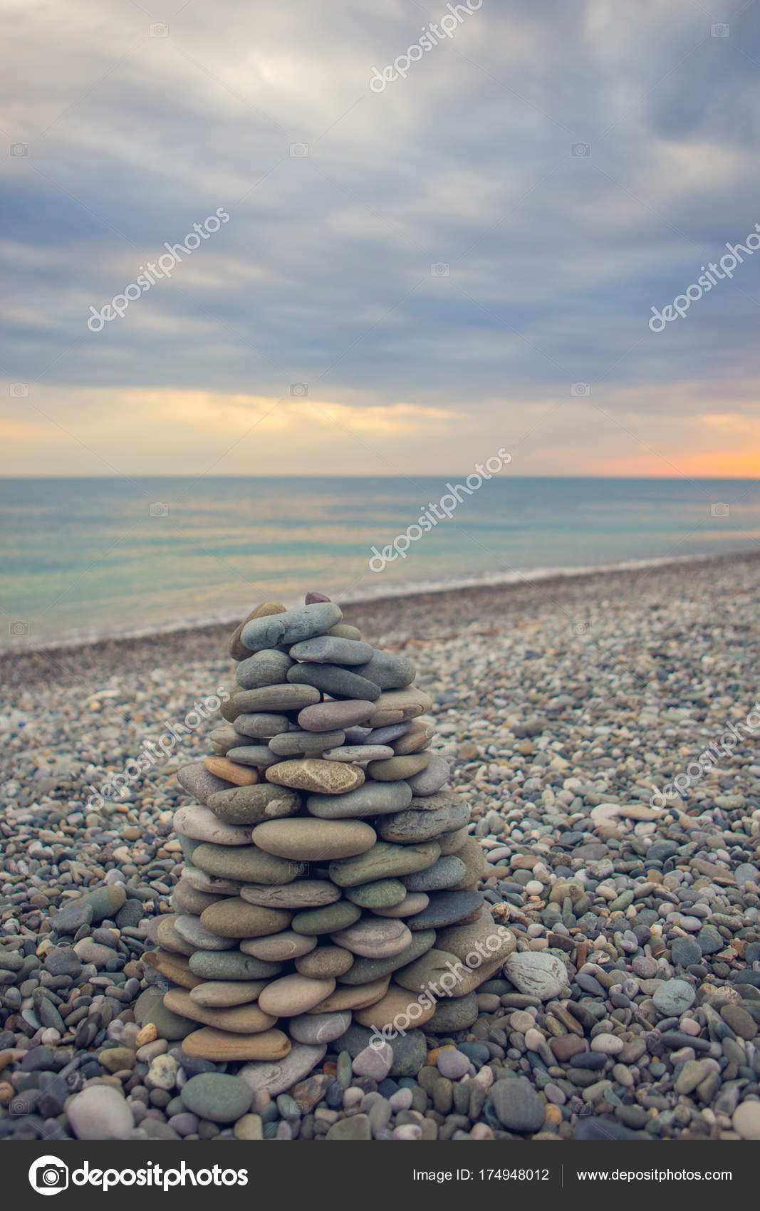 Zen Stones Stack On The Beach With Sea Surf Behind Pebble Tower And Water Waves With Zen Stones Stack On The Beach With Sea Surf Behind Pebble Tower And Water Waves With