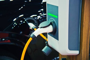 Elektrikli araba aküsünü şarj ediyorum.