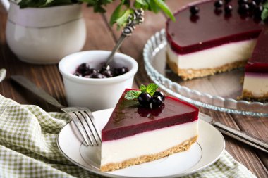 bir cam tabak, nane yaprakları ve Frenk üzümü berries.a kase çilek ve vintage bir kaşık ile Siyah frenk üzümü tabakası ile lezzetli peynirli kek ile natürmort, küçük bir beyaz sürahisi nane ile masaya şubeleri