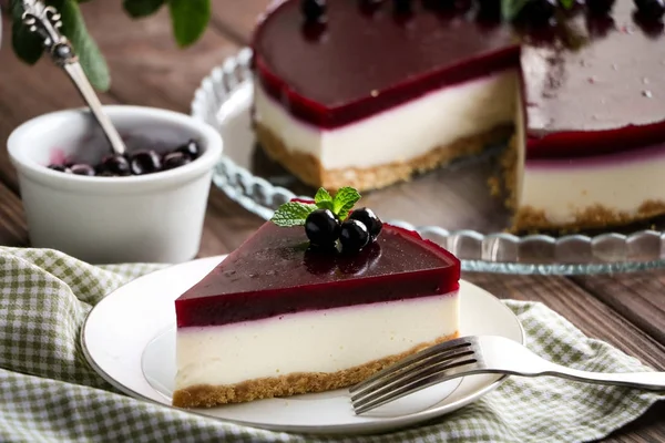 nefis ve lezzetli peynirli kek bir cam tabak, nane yaprakları ve Frenk üzümü berries.a kase çilek ve vintage bir kaşık ile Siyah frenk üzümü ile küçük bir beyaz sürahisi nane ile ahşap masaya şubeleri