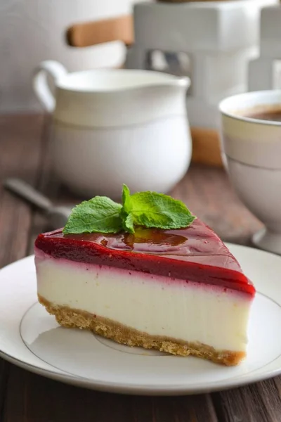 Beyaz yemek, kahve ve süt kabı kahverengi ahşap bir masa üzerinde lezzetli vişneli cheesecake dilim