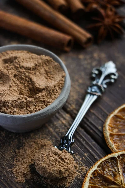 el yapımı kil kase, vintage kaşık, tarçın kokulu tarçın sopa, iki portakal dilimleri, anason yıldızlı,, kahverengi ahşap masa