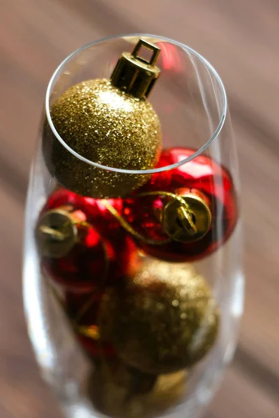 Gouden en rode christmas speelgoed met glitters in glas, Kerstverlichting en decoratie, bruin houten achtergrond, vakanties, nieuwe jaar vooravond Rechtenvrije Stockafbeeldingen