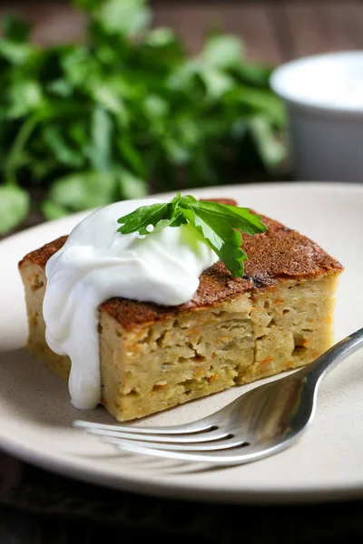 Smakelijke braadpan met kool, zure room en peterselie blad close-up op een bruin houten tafel, gezonde voeding voor de vegan Stockfoto