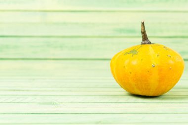 Sonbahar sarı kabak yeşil ahşap zemin üzerine